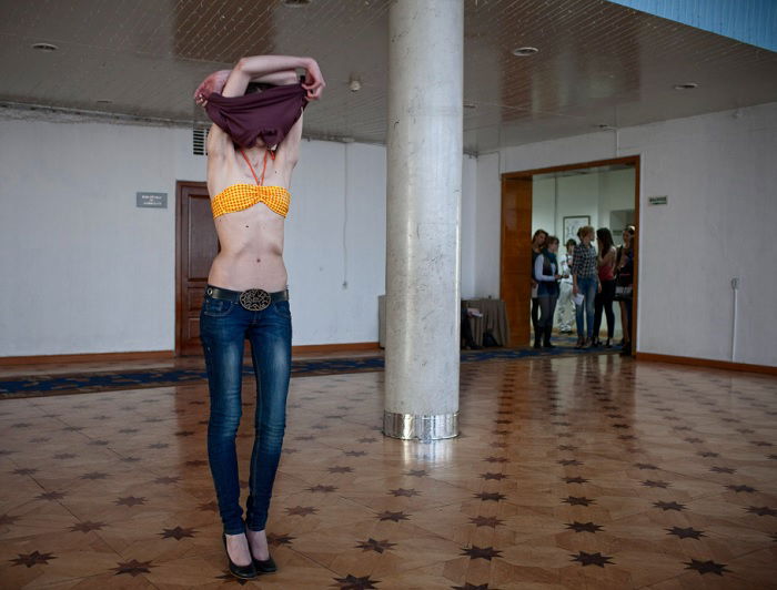 Woman taking top off in an empty show room