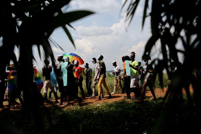 Group of people walking seen through a bush