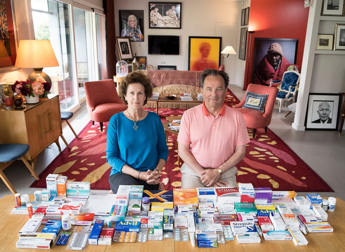 Middle-aged couple sitting in living room behind table of drugs