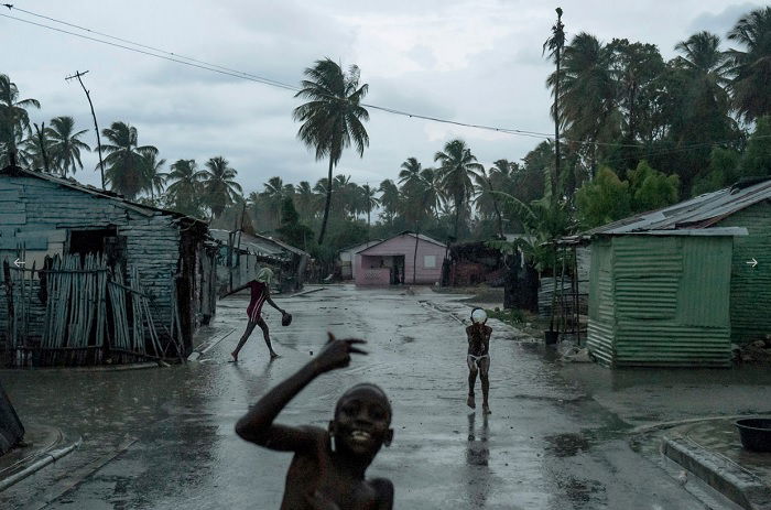 Boy dancing in village street in the rain