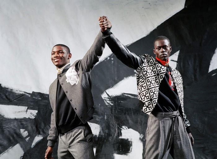 Two young men raising their hands together