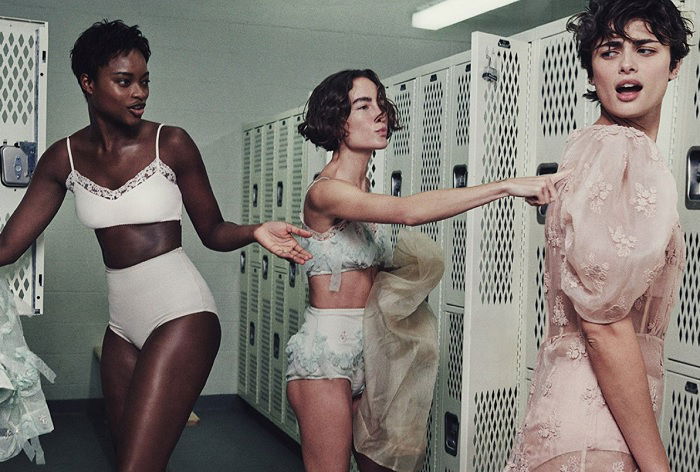 Three young women changing in a locker room