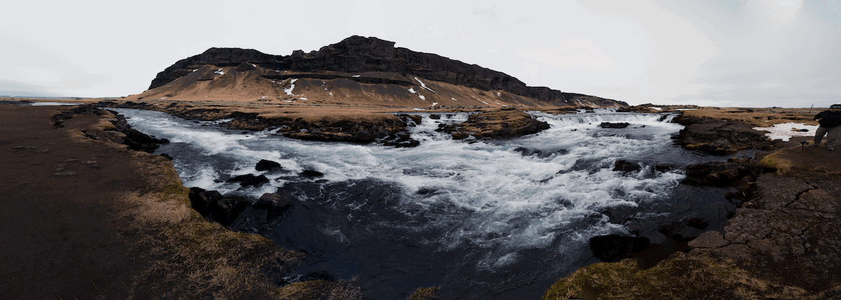 panorama photo of mountain with river in the foreground