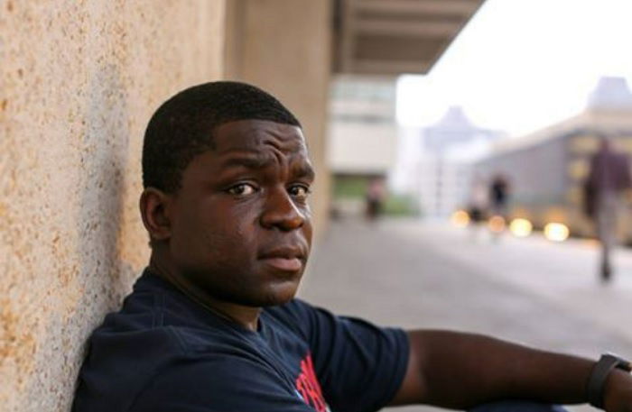 Portrait of young man still in on the street