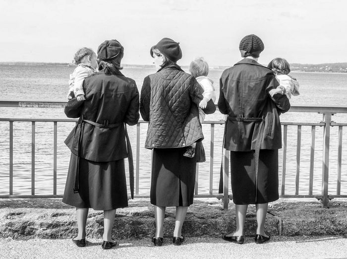 Three woman facing away holding babies