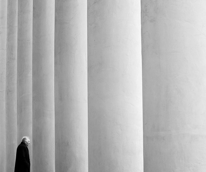 Colonnade with man walking between two columns