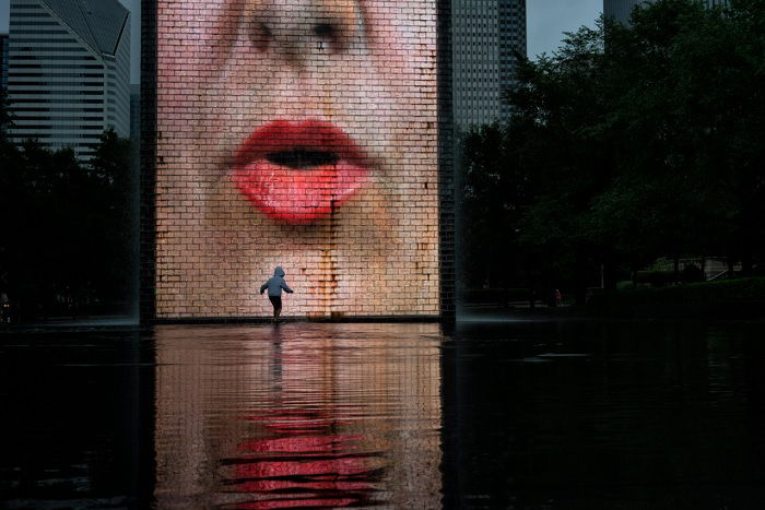 Child playing by advertizing board with lips on it