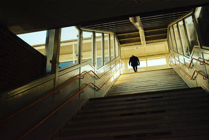 Below view looking up a flight of stairs with man at top