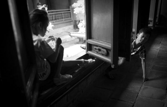 Young girl and boy play in a window