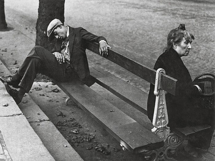 Man sleeping on bench with woman on the other side