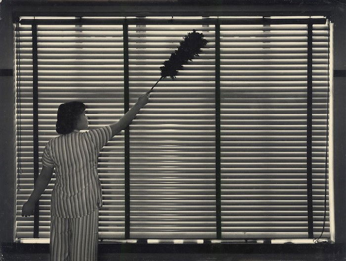 Woman cleaning window blinds