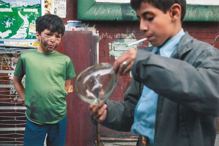 One boy looking at another boy smoking