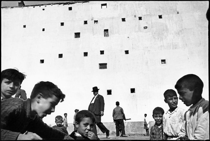 Children and adults in front of a big wall