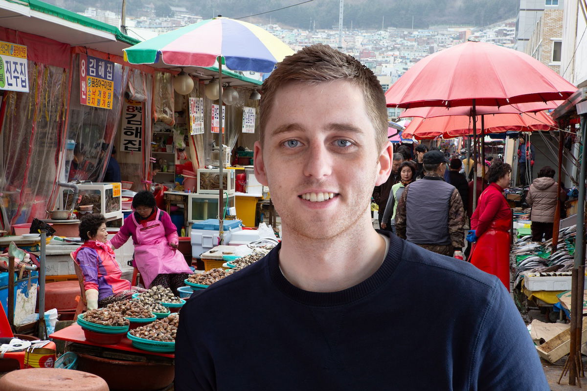 portrait of a man standing in front of a market