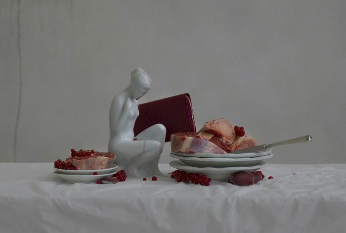 Still life of small statue and slabs of meat