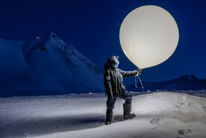 Scientist in the arctic with weather balloon