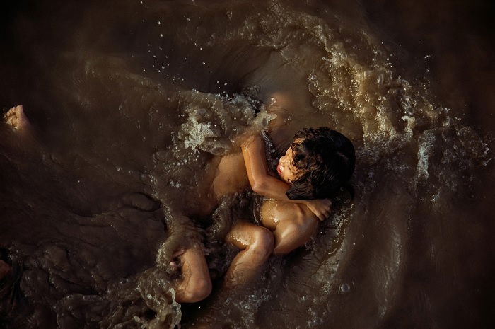 Two young people in fast-running water