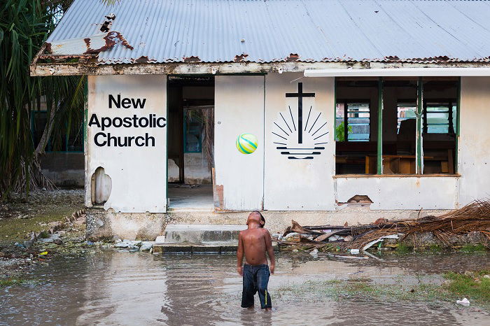 Boy outside flooded shack church