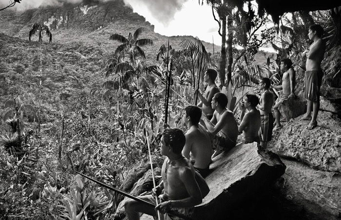 Indigenous people on crest overlooking jungle