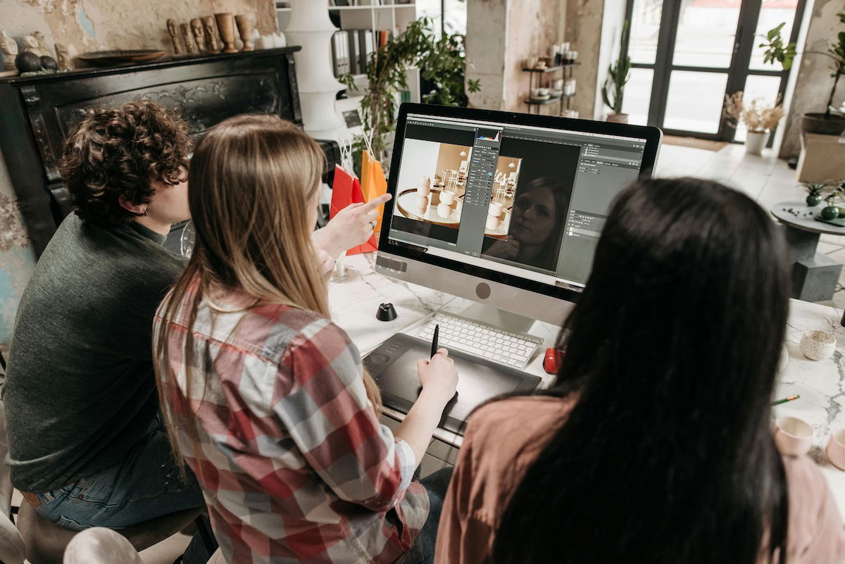 people sitting around a computer using photoshop