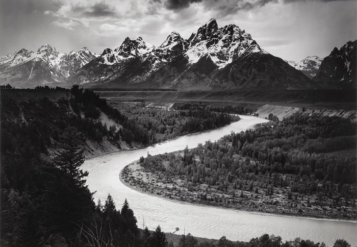 Black and white landscape of river with mountain in background