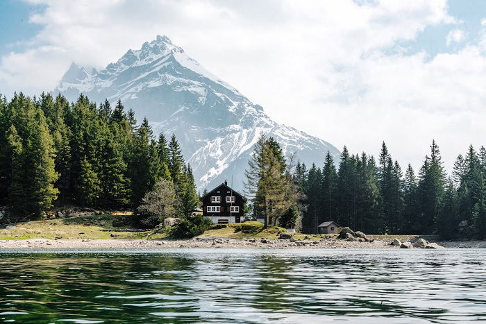 Landscape of lake with house on shore with mountain behind