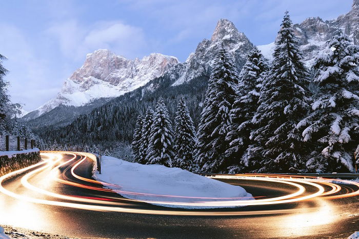 Long-exposure shot of car on bend in mountain road