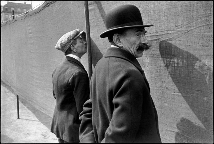 Henri Cartier-Bresson shot of two men facing a wall